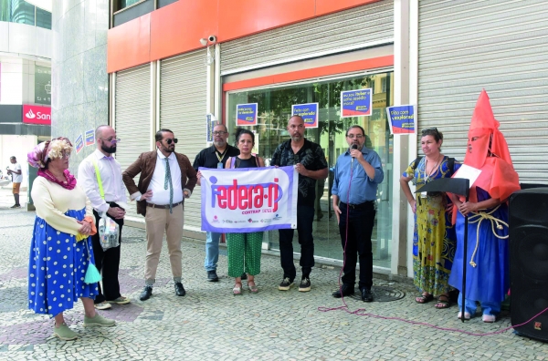  O Sindicato protestou contra as metas que adoecem os bancários, demissões e fechamento de agências no Itaú. Atores participaram da manifestação e prestaram homenagem ao ex-ator e diretor da Cia de Emergência Teatral, já falecido, Marco Aurélio Hamellin. 